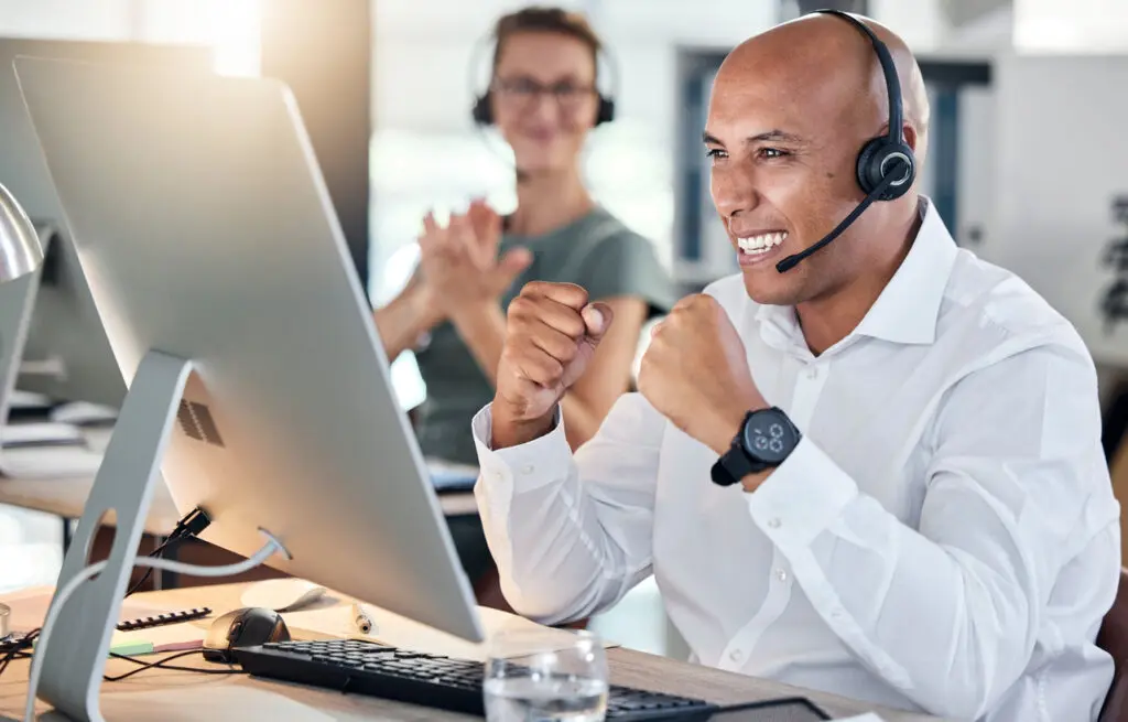Customer service, telemarketing and contact us worker celebration for promotion, sale or goal in call center. Black man working with crm, communication or support online while excited, target or wow - CDConnet Clinical research coordinator celebrating.